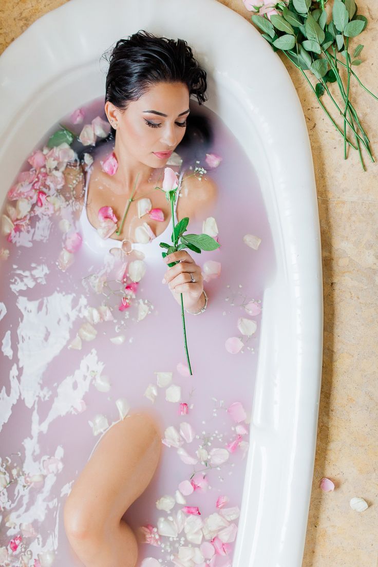 A lady in a luxury spa in a private jacuzzi with milk bath and roses getting a cleopatra treatment